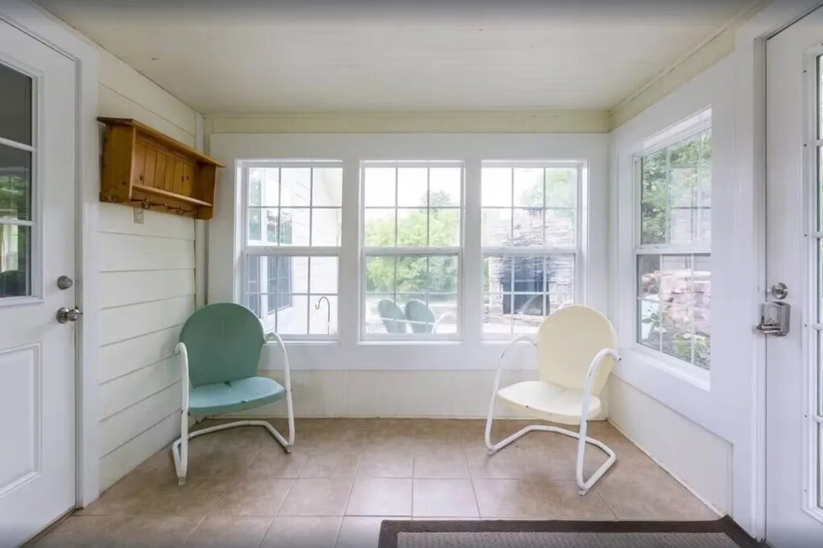This image captures a sunlit interior featuring a green and a yellow chair positioned near large windows. The expansive windows offer a direct connection to the outside, inviting in natural light and scenic views, ideal for morning coffee or quiet conversation. The setup encourages relaxation and social interaction, echoing the spirit of gathering and unwinding after adventures.